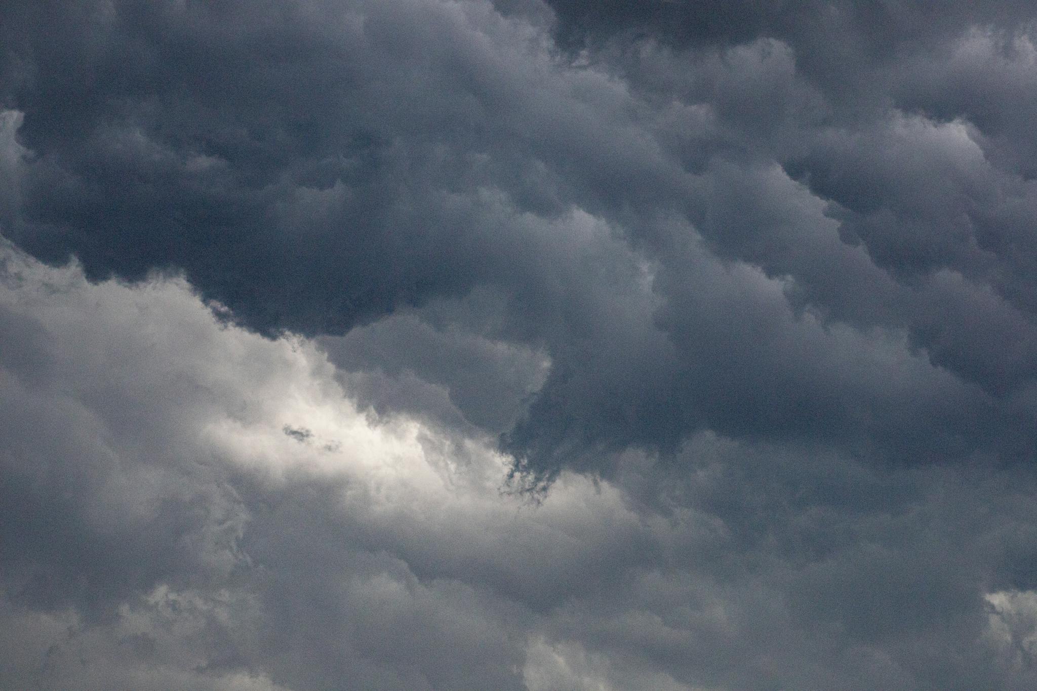 A captivating image of dense, dark clouds in a dramatic overcast sky, hinting at a storm.